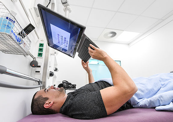 Proband in Kopftieflage im Bett am Computer. © DLR. Alle Rechte vorbehalten.