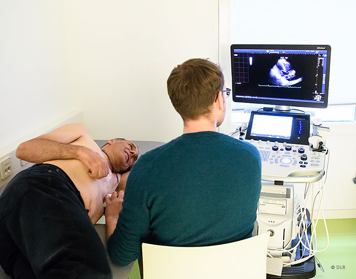 Proband bei einer Ultraschalluntersuchung durch einen Mitarbeitenden. © DLR. Alle Rechte vorbehalten.