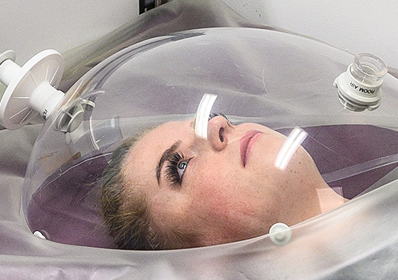 Probandin unter einer RMR-Haube. © DLR. Alle Rechte vorbehalten.